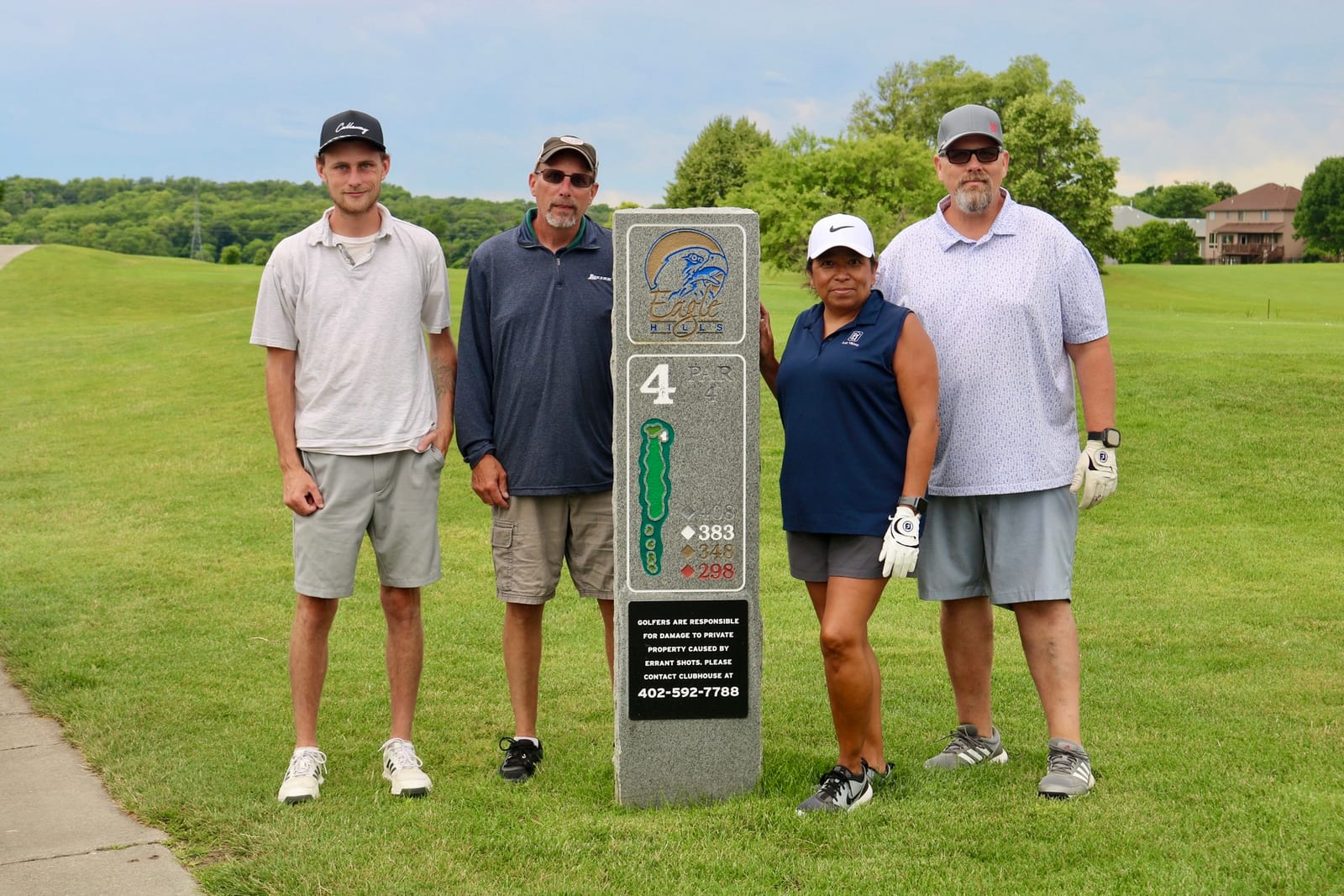 Golf scramble participants standing between golf carts at Eagle Hills Golf Course
